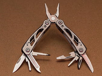 Open Multi-Tool Pliers on Brown Background