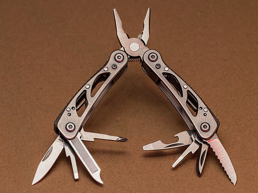 Open Multi-Tool Pliers on Brown Background