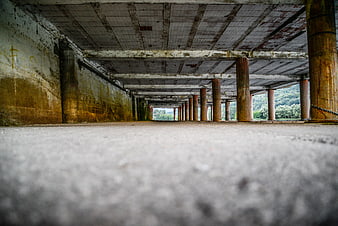 Low angle view of concrete pillars in abandoned parking garage
