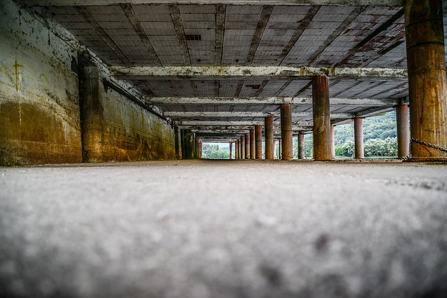 Low angle view of concrete pillars in abandoned parking garage