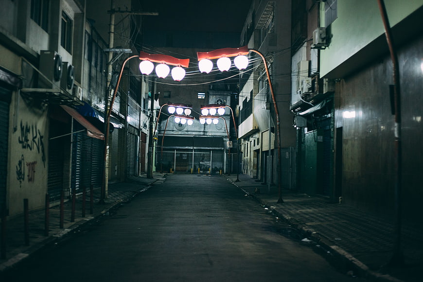 Moody Nighttime Urban Alleyway With Glowing Street Lamps