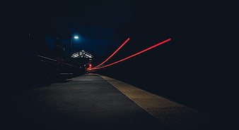 Long Exposure Red Light Trails on Dark Train Platform at Night