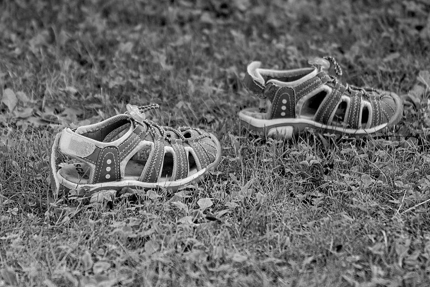 Black and White Photo of Toddler Sandals on Grass
