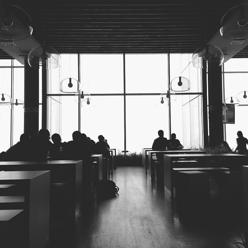 Silhouettes of people in a modern office cafeteria
