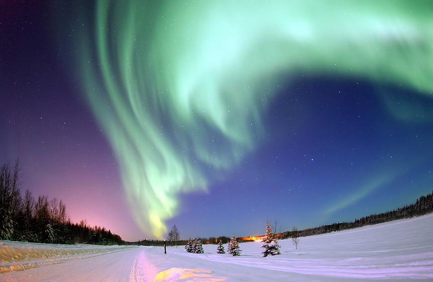 Green Aurora Borealis Over Snowy Winter Landscape
