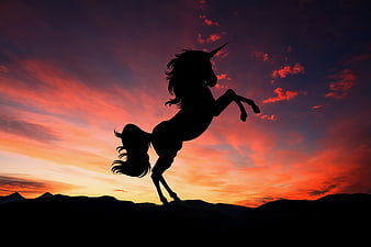 Silhouette of a rearing unicorn against a vibrant sunset sky