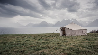 Glamping Tent by Fjord with Mountains and Cloudy Sky