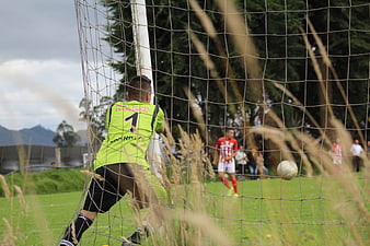 Soccer Goalkeeper in Action Behind Net