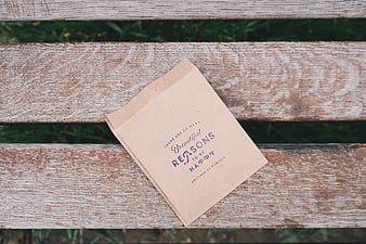 Brown paper bag with positive quote on wooden bench