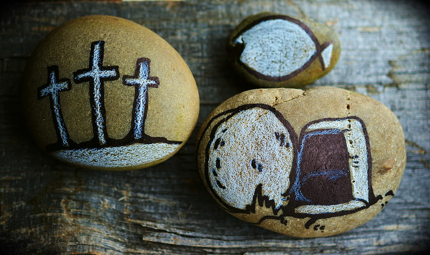 Hand-painted religious symbols on smooth river stones