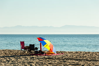 Colorful Beach Umbrella and Chairs on Sandy Shore