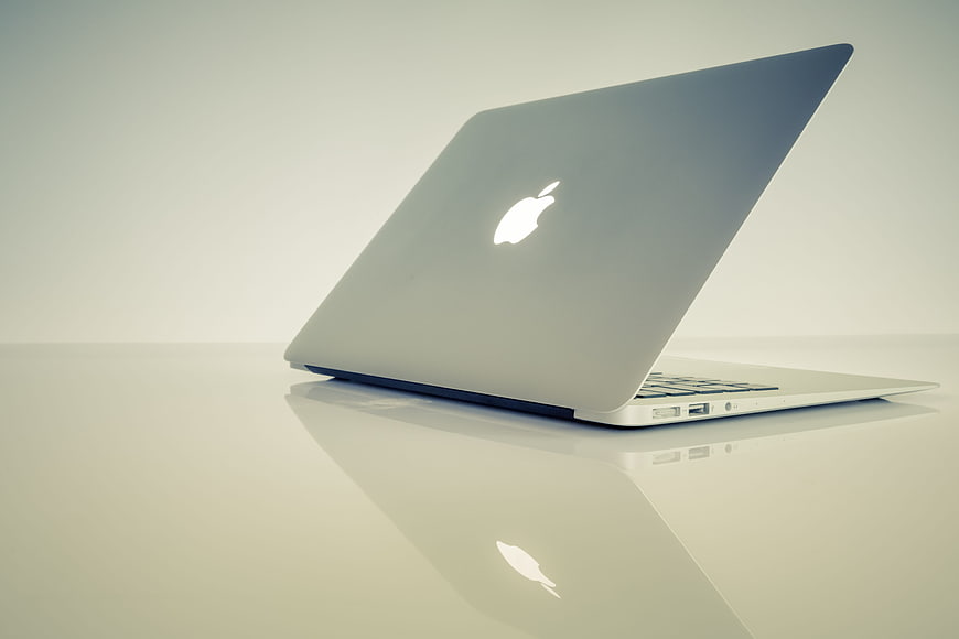 Silver MacBook Laptop on White Reflective Surface