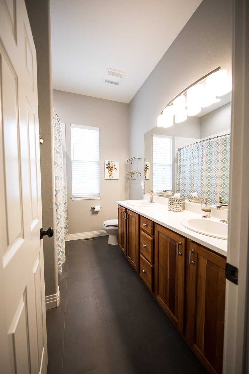 Modern bathroom interior with double vanity and wooden cabinets