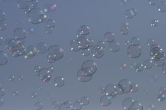 Floating Soap Bubbles with Iridescent Highlights on Blue Background