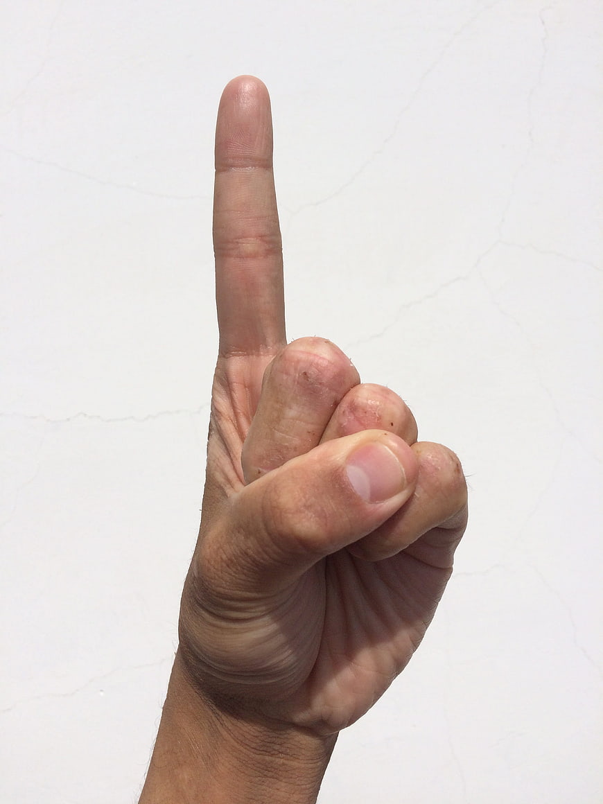 Hand pointing up index finger against white background