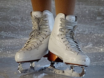 Close-up of worn white figure skates on ice
