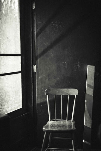 Vintage wooden chair in dark room with window light