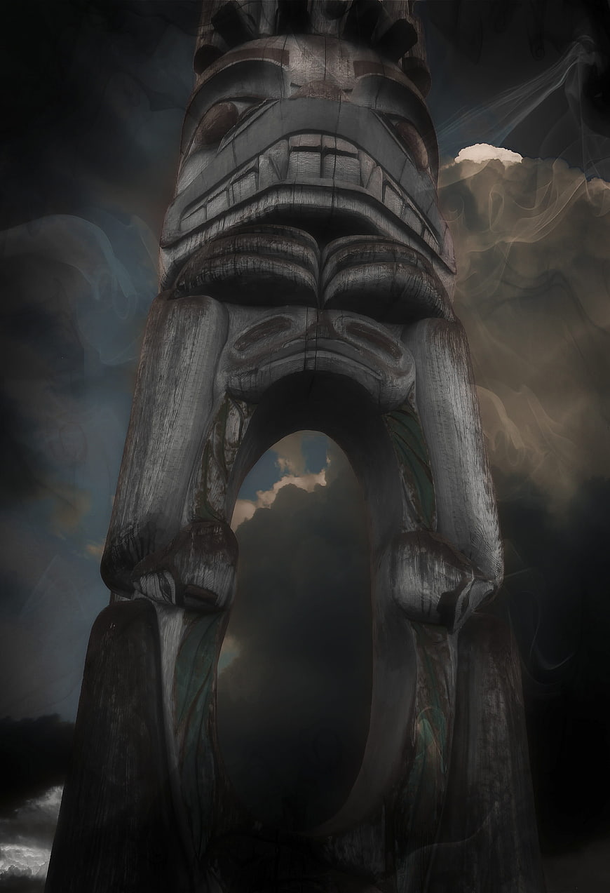Dramatic Low Angle Totem Pole Sculpture Against Stormy Sky
