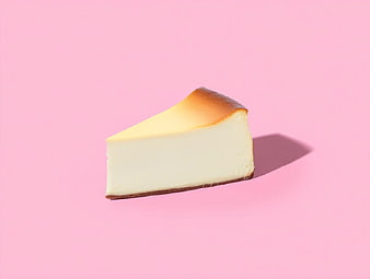 Slice of creamy cheesecake on pastel pink background