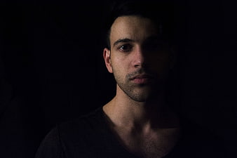Dramatic low-key portrait of a man in shadows