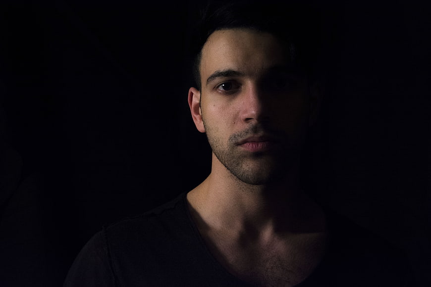 Dramatic low-key portrait of a man in shadows