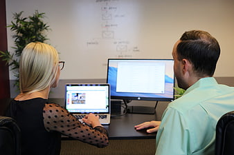 Business Team Reviewing Website Design on Laptop and Monitor