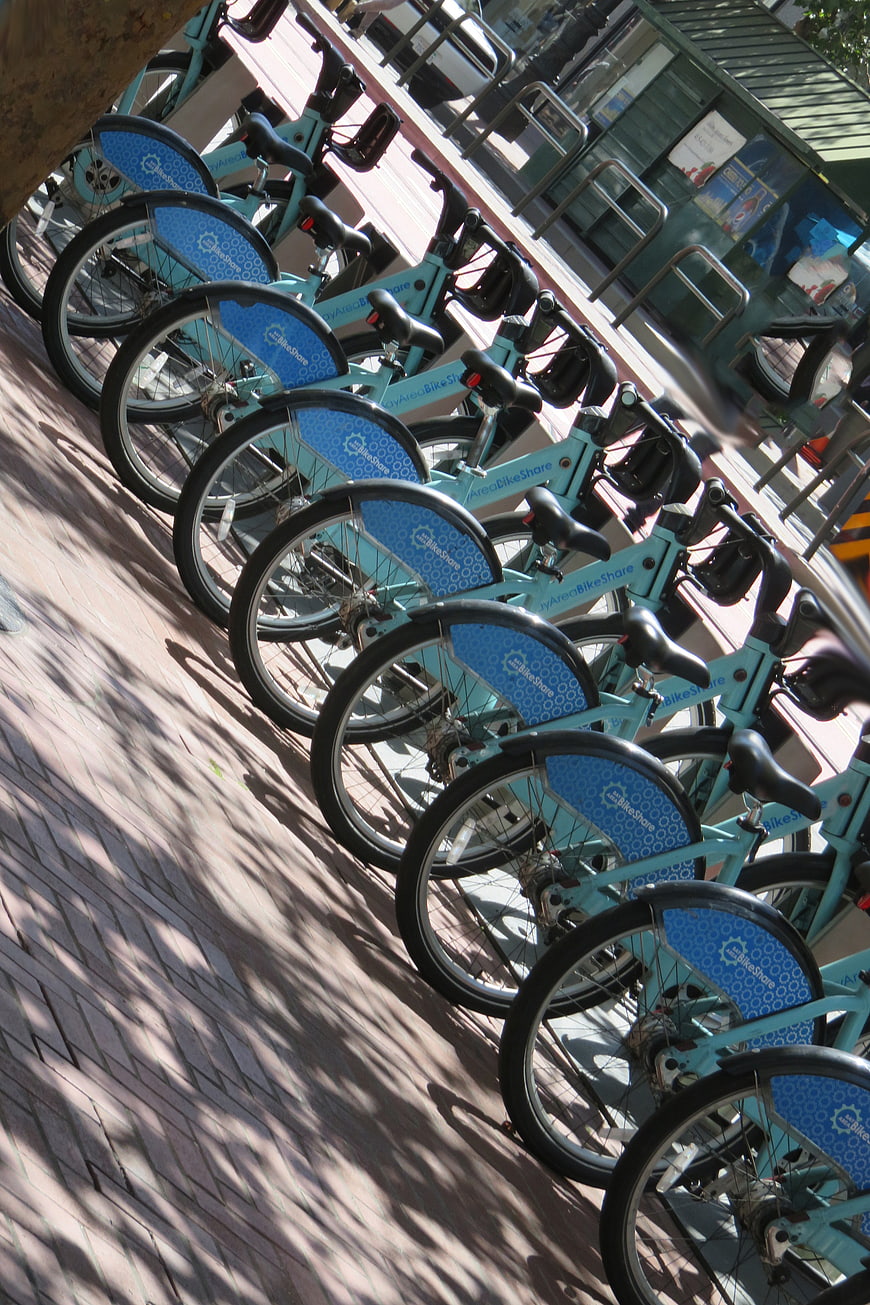 Row of blue HyArea BikeShare bicycles on city sidewalk