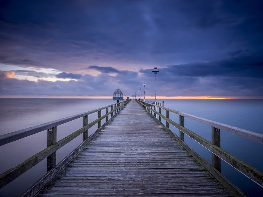 Long Exposure Wooden Pier at Blue Hour Over Calm Sea