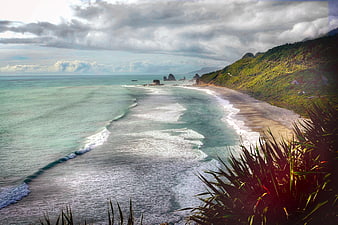 Scenic tropical coastline with turquoise waves and lush green hills
