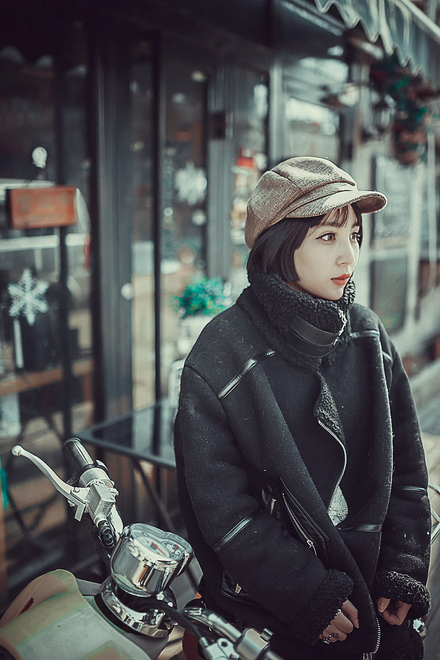 Woman in Vintage Cap Sitting on Motorcycle
