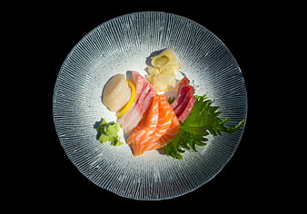 Assorted sashimi platter on textured ceramic plate