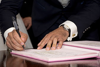 Man in Suit Signing Marriage Register with Pen