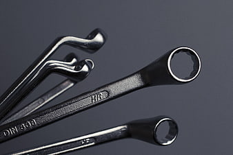 Close-up of black metal wrenches and allen keys on gray background