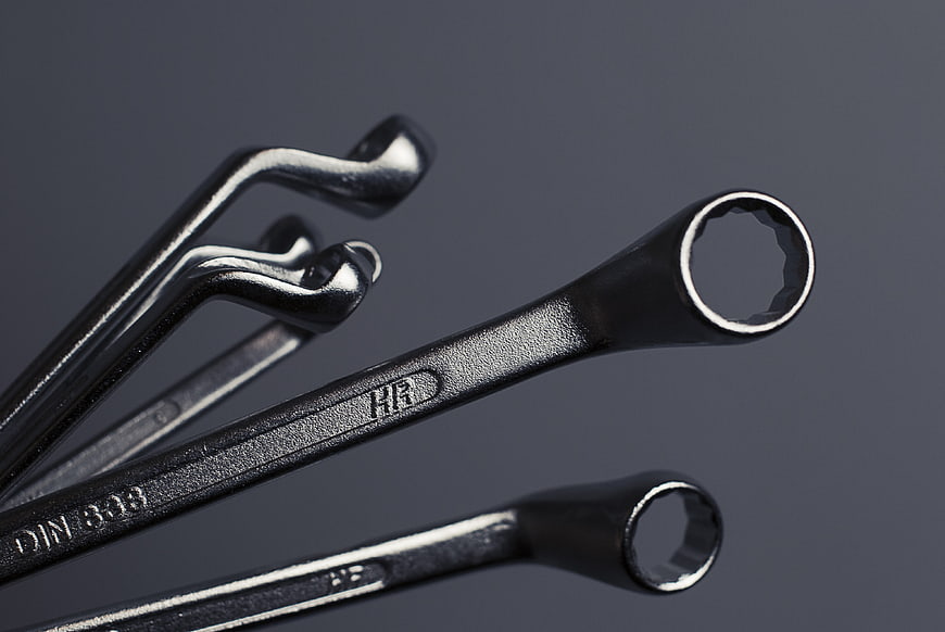 Close-up of black metal wrenches and allen keys on gray background