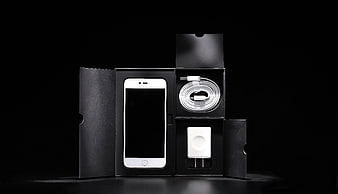 White Smartphone Unboxed with Charger and Cable on Black Background