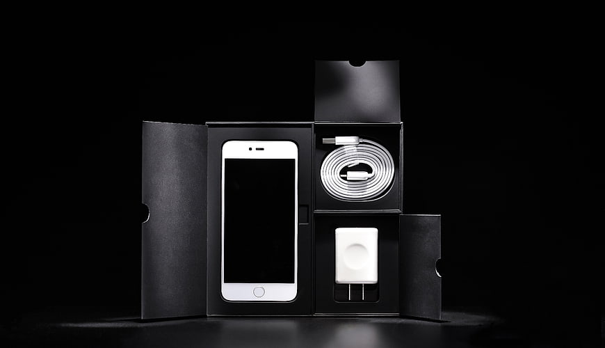 White Smartphone Unboxed with Charger and Cable on Black Background