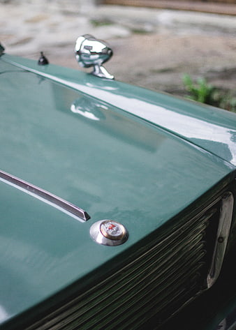 Close-up of vintage green car hood with chrome details