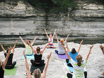 Group Yoga Class on Rocky Cliffside by River