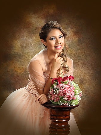 Young woman in pink quinceañera dress with flower bouquet