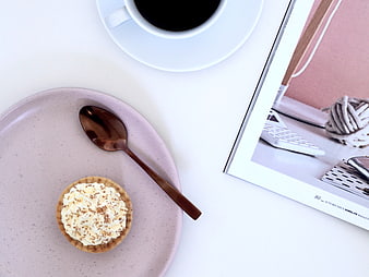Flat lay of coffee, tart, and magazine on white table