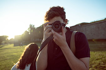 Young Man Taking Photo with DSLR Camera Outdoors