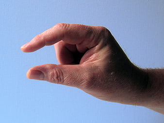 Hand Gesturing Small Distance Against Blue Sky