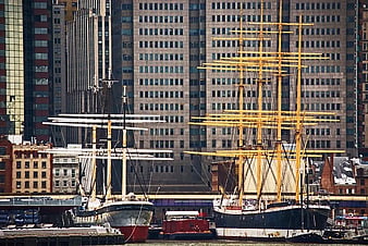 Historic Tall Ships Docked in Urban Harbor