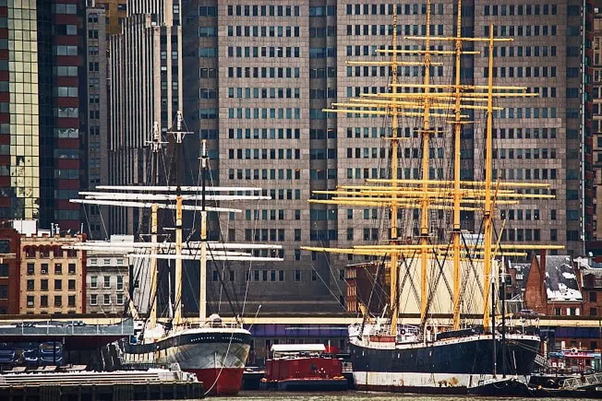 Historic Tall Ships Docked in Urban Harbor