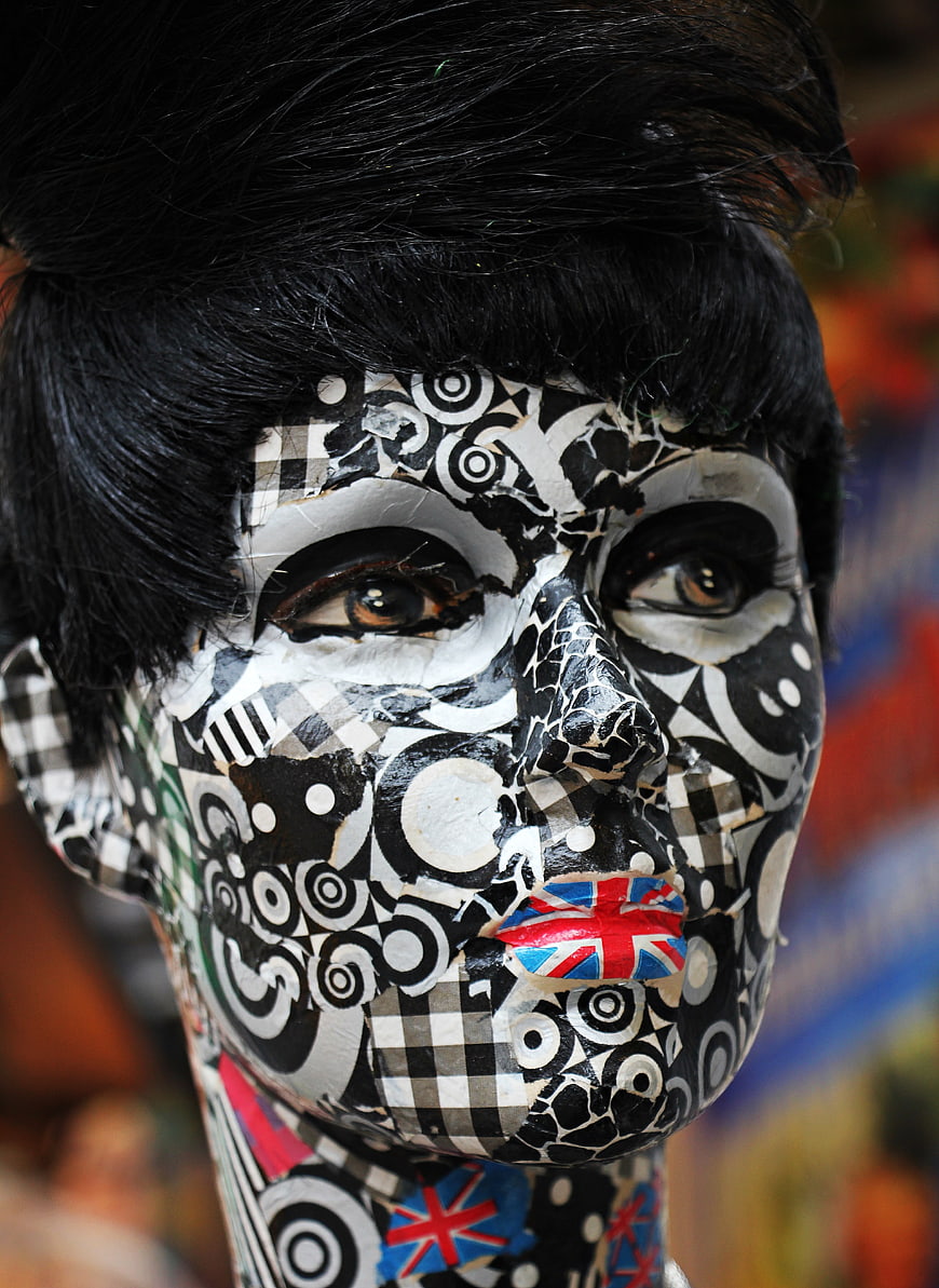 Decorated mannequin head with black and white geometric pattern and British flag lips