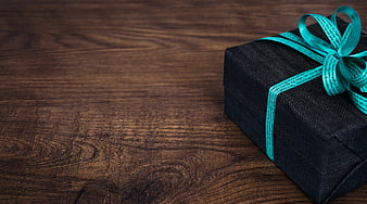 Black Gift Box with Teal Ribbon on Wooden Background