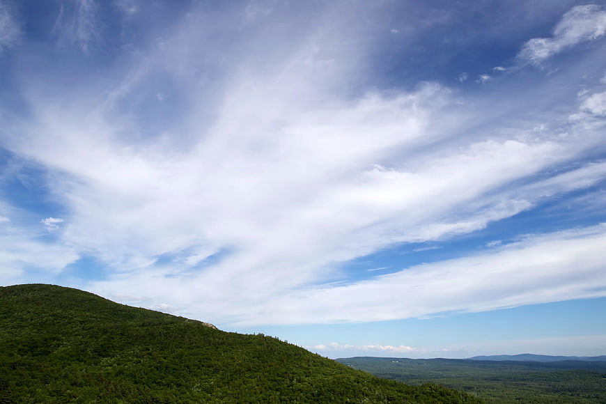 Green Mountain Ridge Under Blue Sky with Wispy Clouds