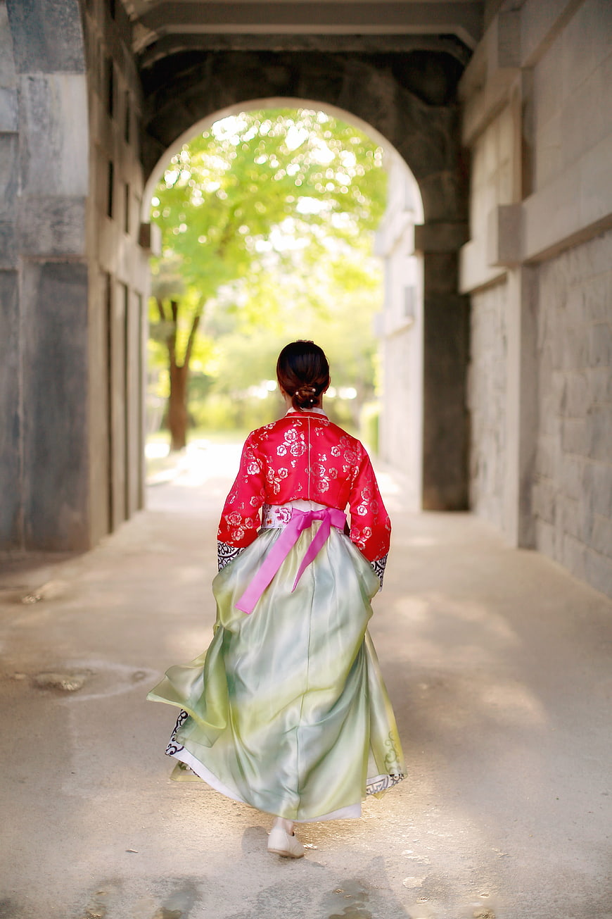 Woman in Traditional Korean Hanbok Walking Through Stone Archway
