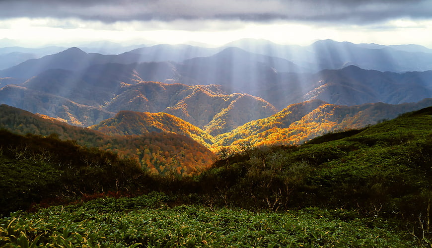 Dramatic Sunbeams Over Autumn Mountain Forest Landscape