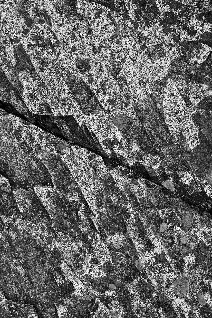 Black and white granite rock texture with diagonal cracks